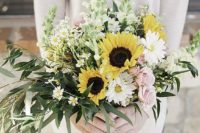 a pale spring wedding bouquet of pink roses, white blooms, sunflowers and lots of greenery