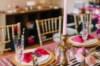 a pink Parisian-inspired bridal shower table with a pink sequin tablecloth, a striped runner, pink candles and pink blooms, gold chargers and cutlery