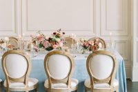 a refined and beautiful Parisian themed bridal shower tablescape with pink and red blooms, pink candles and greenery is adorable