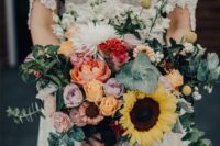 a romantic textural wedding bouquet of sunflowers, pastel blooms and red and white ones plus greenery