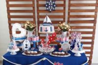 a simple and cute nautical bridal shower dessert table with a banner, some nautical decor, an anchor marquee light and tasty desserts