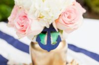 a simple bridal shower centerpiece with a gilded vase, a navy anchor, neutral and pink blooms plus net