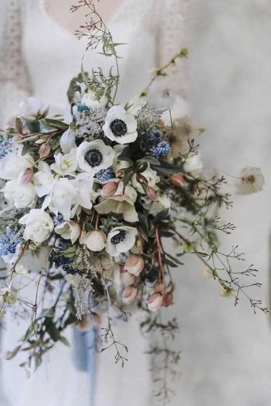 a stylish spring wedding bouquet of white anemones, various fresh spring blooms, branches and twigs is a chic idea with much dimension