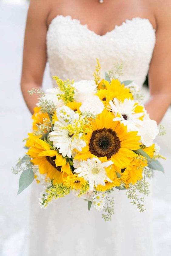 a stylish wedding bouquet of white blooms and sunflowers plus touches of greenery for a summer bride