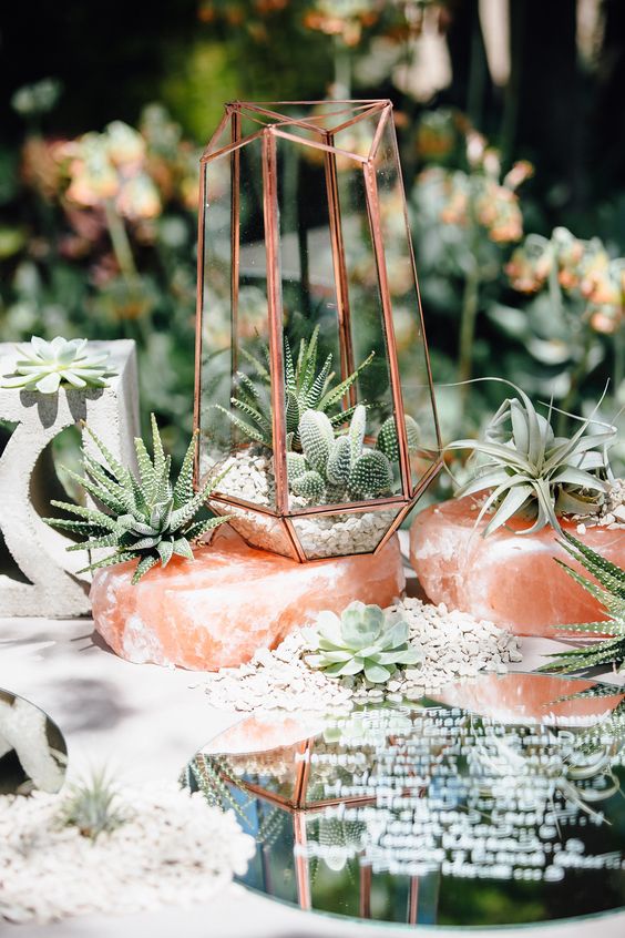 a unique boho wedding centerpiece of pink rocks, succulents and cacti, a concrete stand and a menu is a lovely idea