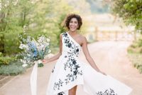 a unique bridal look with a one shoulder high low wedding dress with black floral embroidery and peep toe cherry blossom boots, a cherry blossom bouquet