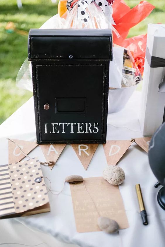 a vintage metal mailbox with white letters, a bunting, some cards and colorful posies