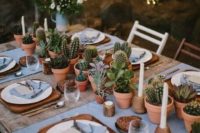 a wedding table runner made of potted cacti and succulents plus white candles is ideal for a desert wedding