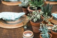 a wedding table runner of potted greenery and succulents plus candles is a cool idea for a modern wedding