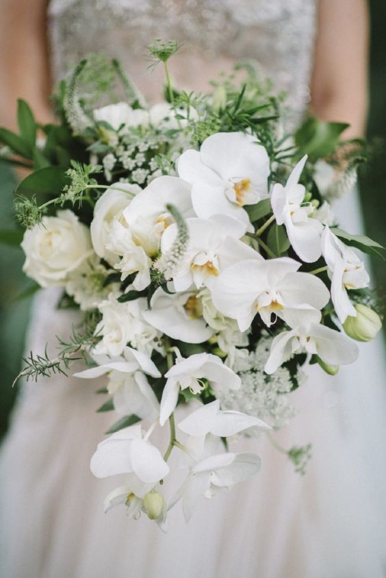 a white orchid and rose wedding bouquet with textural greenery is a chic idea for a modenr bride