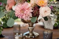 an elegant fall wedding centerpiece of blush and purpel dahlias, white and pink roses and some fillers and eucalyptus