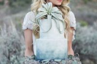 an ombre blue wedding cake served wiht greenery, hay and an air plant on top is a great idea for a boho wedding
