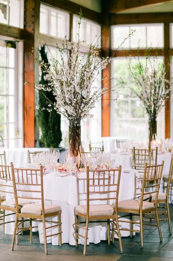 blush tablecloths echo with cherry blossom branches and create a stunning table setting