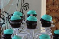 chocolate cupcakes with tiffany blue icing and diamond rings as toppers