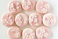 glazed pink wedding cookies decorated with pink cherry blossom and beads and petals will give a romantic feel to your wedding dessert table