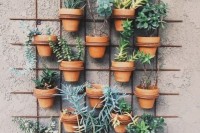 a wall with a planter grid and lots of succulents and greenery to refresh the space and decorate it