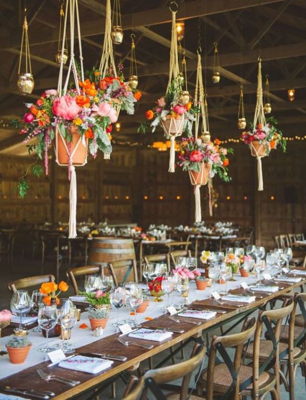 potted flowers and greenery on the table and over it to decorate the wedding reception space in a sustainable way