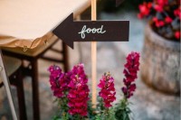 a pot with bright flowers and signs is a cool wedding decoration for any modern wedding