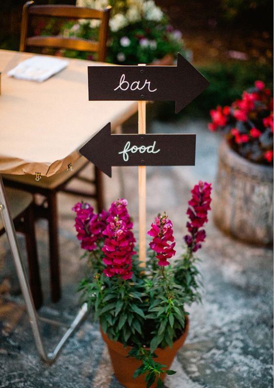 a pot with bright flowers and signs is a cool wedding decoration for any modern wedding