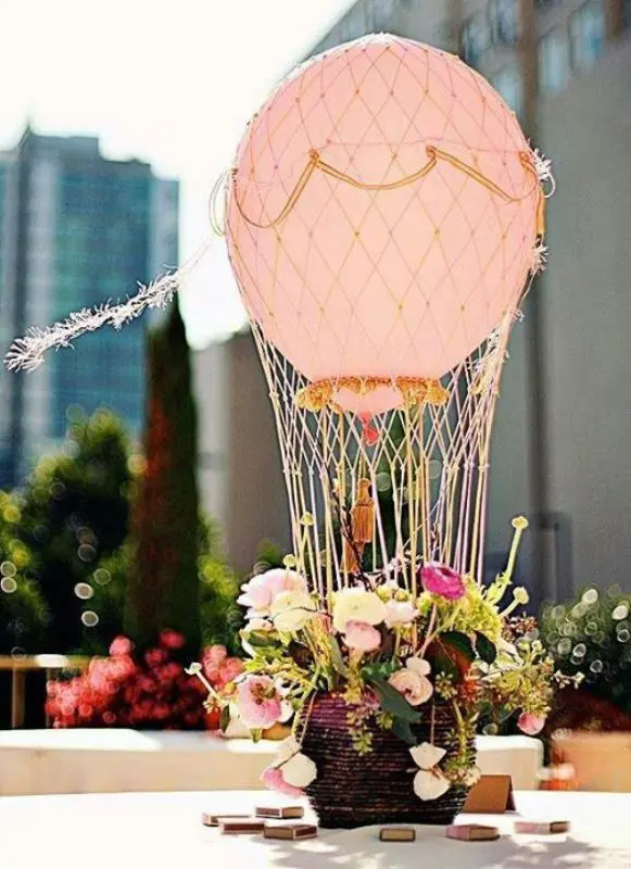 a dreamy hot air balloon wedding centerpiece with fresh flowers and greenery for a modern wedding