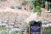 potted greenery and candles decorate the wedding ceremony space and a chalkboard sign adds to it