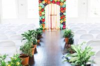 potted plants and flowers line up the aisle and make it bold and outdoorsy, though it’s indoors