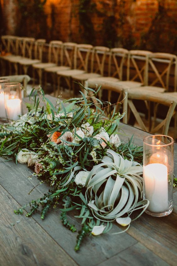 pretty wedding table decor with greenery, neutral and pastel blooms and candles in glasses is a lovely and unique solution