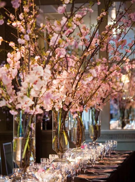tall vases with pink cherry blossom and candles around instantly create a wow factor at your reception space
