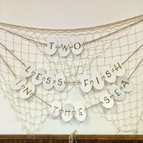 a mermaid bridal shower decoration of net and banners is a creative idea that you can easily DIY