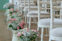a beautiful vintage wedding aisle with white vintage chairs, white jugs lining up the aisle and holding pink roses and white baby’s breath is an elegant and ethereal idea