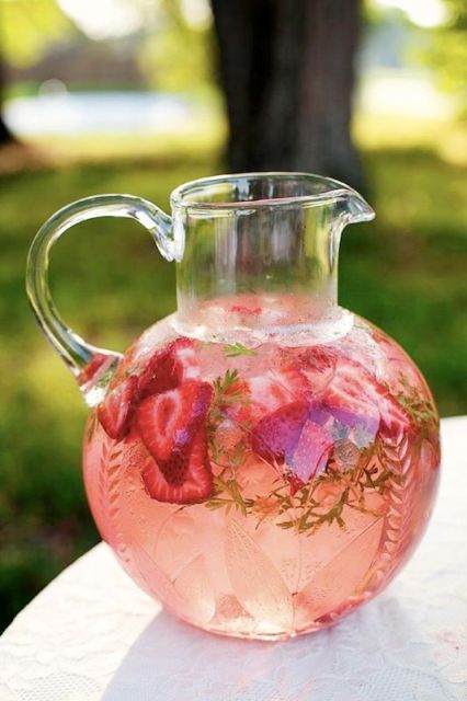 a glass pitcher used to serve strawberry lemonade with berries is a great idea for any summer wedding
