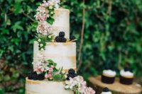 Wedding cake and cupcakes decorated with blackberries