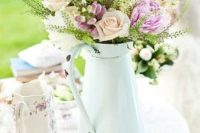 a spring or summer wedding centerpiece of a mint green jug of metal and blush and pink blooms and greenery is cool
