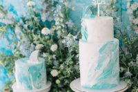 a bold mermaid bridal shower dessert table with white and turquoise wave cakes, turquoise macarons and shark and starfish cookies