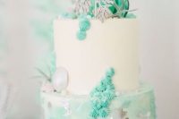 a bright and cool mermaid bridal shower cake in white and greens imitating the sea – seashells, meringues, air plants and waves on top