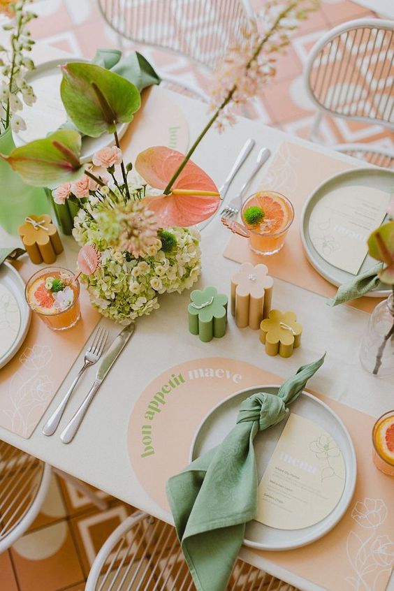 a bright spring retro bridal shower with peachy placemats, muted color candles, matching floral arrangements and green napkins
