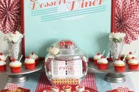 a colorful retro dessert table with a turquoise sign in a red frame, a red and turquoise runner and various delicious desserts