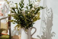 a pretty floral wedding arrangement with a white jug and white blooms and greenery for a rustic wedding