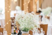 a super simple rustic wedding centerpiece of a metal jug with baby’s breath and a cardboard tag is amazing for a rustic wedding