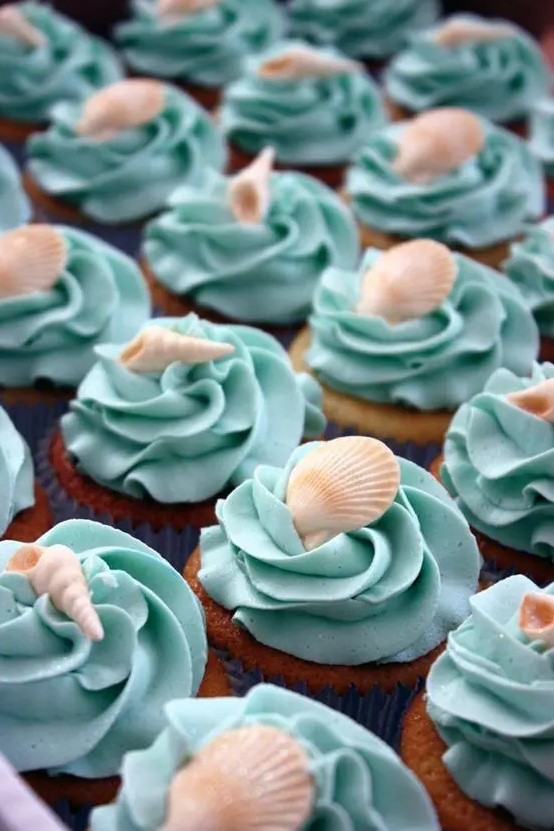 cupcakes with turquoise frosting and edible seashells on top will be great for any sea-inspired party or celebration