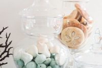 glass jars with nut cookies and little white and green meringues are amazing