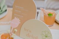 lovely bright wedding signage in light yellow and orange, with orange placemats and some colorful drinks and drink toppers