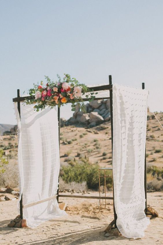 flowy arch decorated with flowers right in the desert