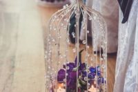 Chic birdcage aisle decor with flowers and candles