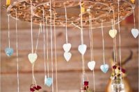 Hanging wagon wheel decor with candles, jars and flowers
