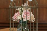 Table centerpiece with birdcage and vase with flowers
