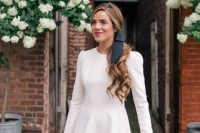 a chic white over the knee dress with a high neckline, long sleeves and a black bow in the hair make up a cool look