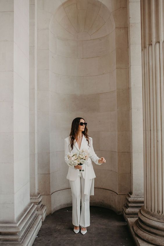 A classy white pantsuit with flare pants and white shoes is great for any wedding related party or a wedding