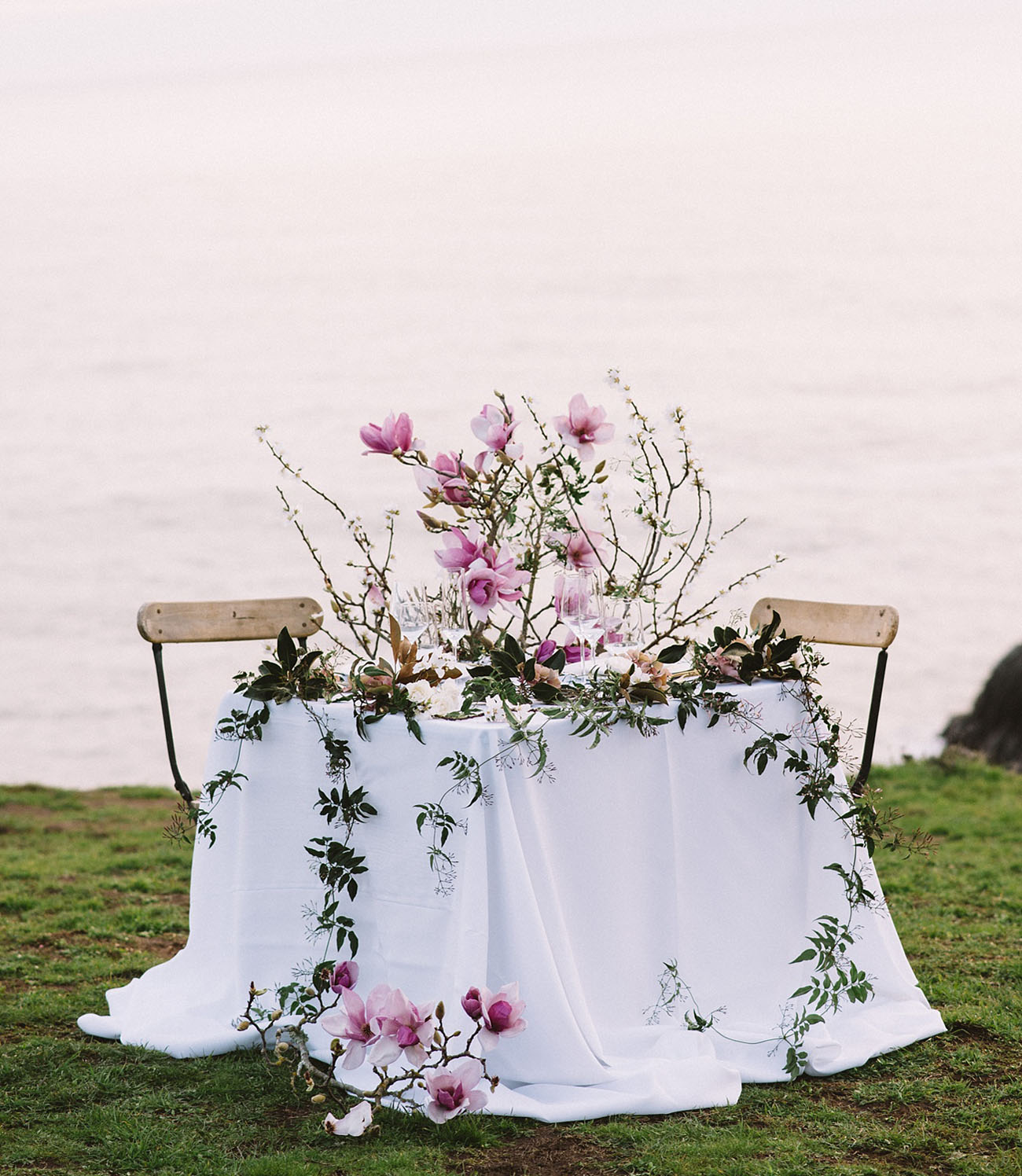 Sweetheart wedding table is decorated with lush pink florals and greenery