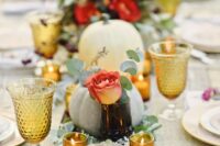 a beautiful fall wedding table setting with pumpkins, roses, eucalyptus, amber glasses and candles is amazing